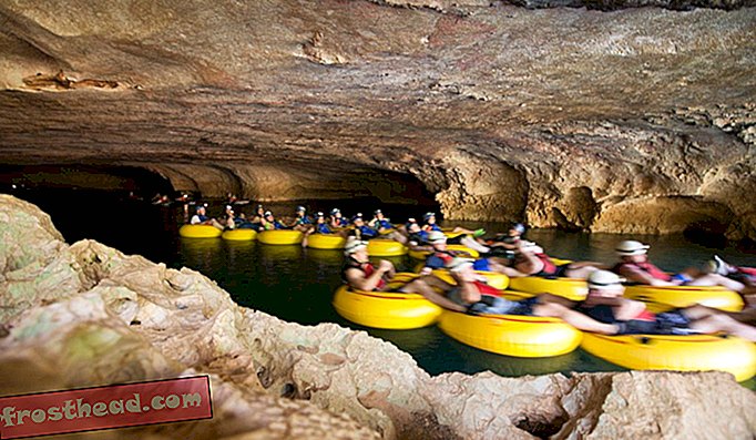 I turisti vanno tubing in una grotta in Belize.