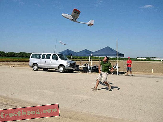 Seorang peneliti meluncurkan drone sementara pilot cadangan siap dengan kontrol radio di tangan