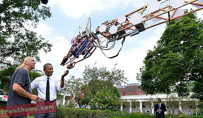 राष्ट्रपति ओबामा ने 18 जून, 2014 को व्हाइट हाउस निर्माता कंपनी फेयर में सैन डिएगो, कैलिफोर्निया के लिंडसे लॉरल के साथ एक रोबोट जिराफ की जांच की।
