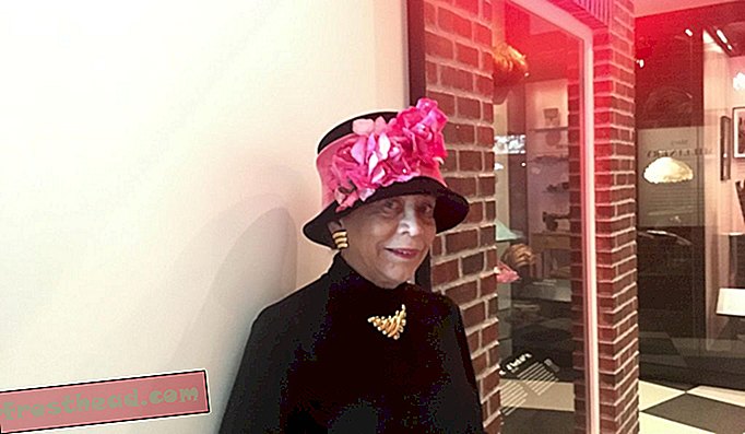 Donna Limerick draagt ​​een replica van een van haar moeders hoedontwerpen tijdens een bezoek aan de tentoonstelling Mae's Millinery Shop in het National Museum of African American History and Culture.