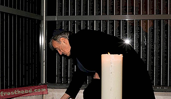 Elie Wiesel tænder et lys for Holocaust-ofre på en mindesmur, der identificerer titusinder af ungarske Holocaust-ofre, i Holocaust Memorial Center i Budapest, Ungarn den 10. december 2009.