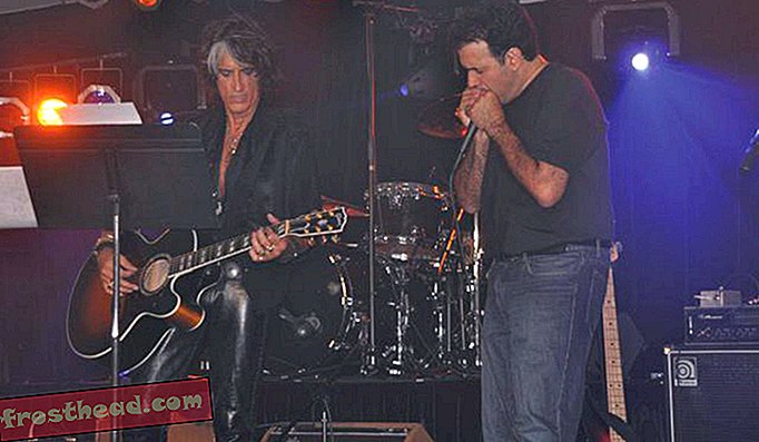 טנזי, שהקליט עם אירוסמית ', מלווה את גיטריסט הראשי של הלהקה ג'ו פרי בקונצרט צדקה ב -2012.