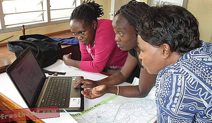 Lucy Fondo, centro de Map Kibera, muestra a dos maestros cómo usar el proyecto de mapeo impulsado por la comunidad que pone a todas las escuelas de Kibera en un mapa.