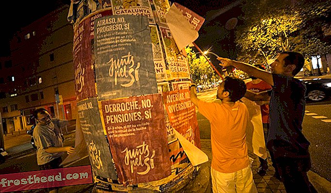 バルセロナ、カタルーニャ、スペイン。 9月17日。独立賛成派の連合活動家、Junts pelSÌ（Together for Yes）の活動家が、バルセロナ市の9バリスの労働者地区でポスターを貼り付けた。