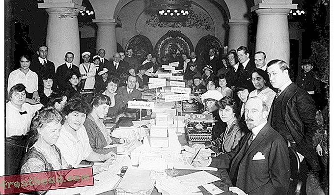 Un groupe de personnes examine les lettres envoyées au père Noël pour l'association du père Noël à l'hôtel Astor à New York en 1914.