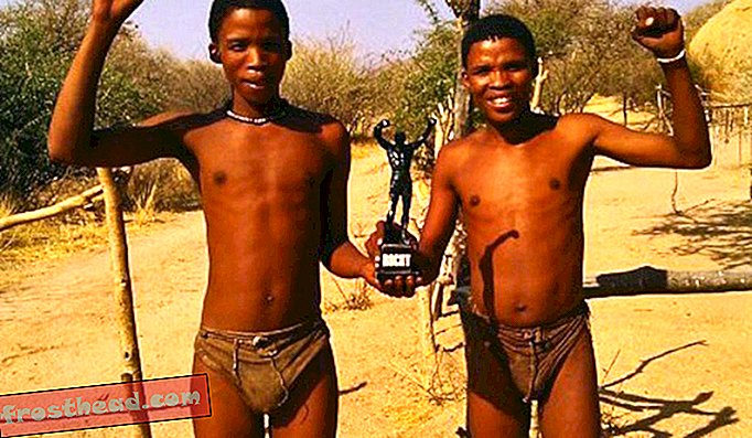 Během Milnesovy návštěvy v Namibii položili na tuto fotografii Little Rocky se dvěma chlapci ze San lidí - kultura uvedená ve filmu Bohové musí být blázen.