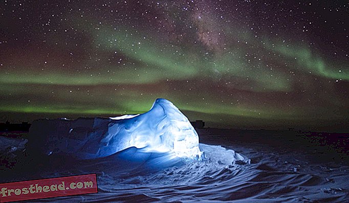 Aurora australis танцува над светодиодно осветено иглу в Антарктида.